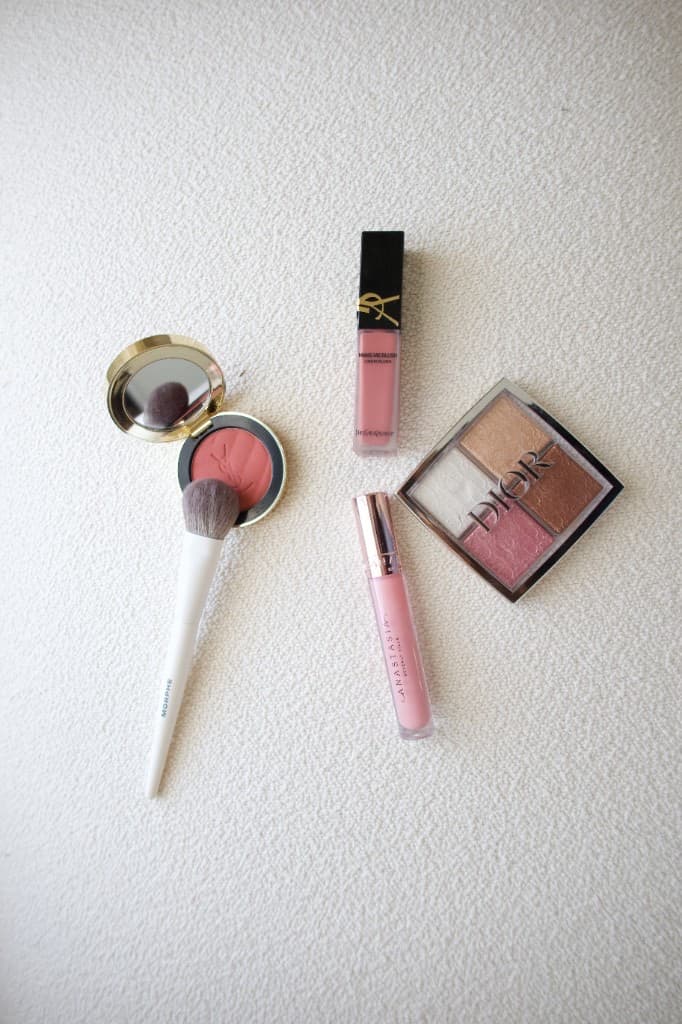 Luxury makeup products including blush, brushes, and glow palette